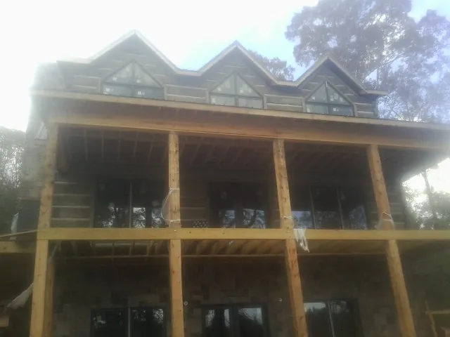 Dormers and porch framing on a large log home under construction — Roof Coating work by our crew in Amissville