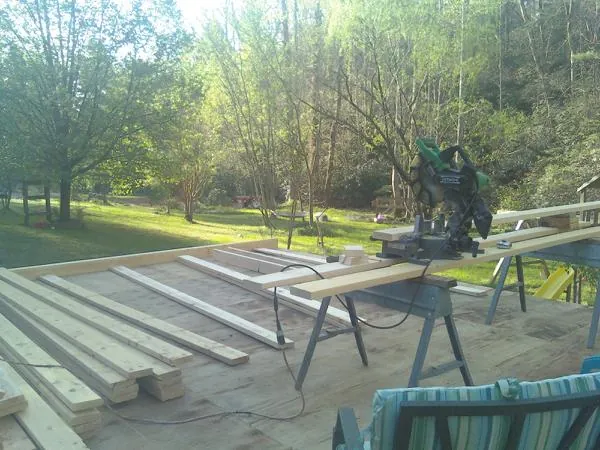 Miter saw and framing lumber on a deck under construction in Amissville
