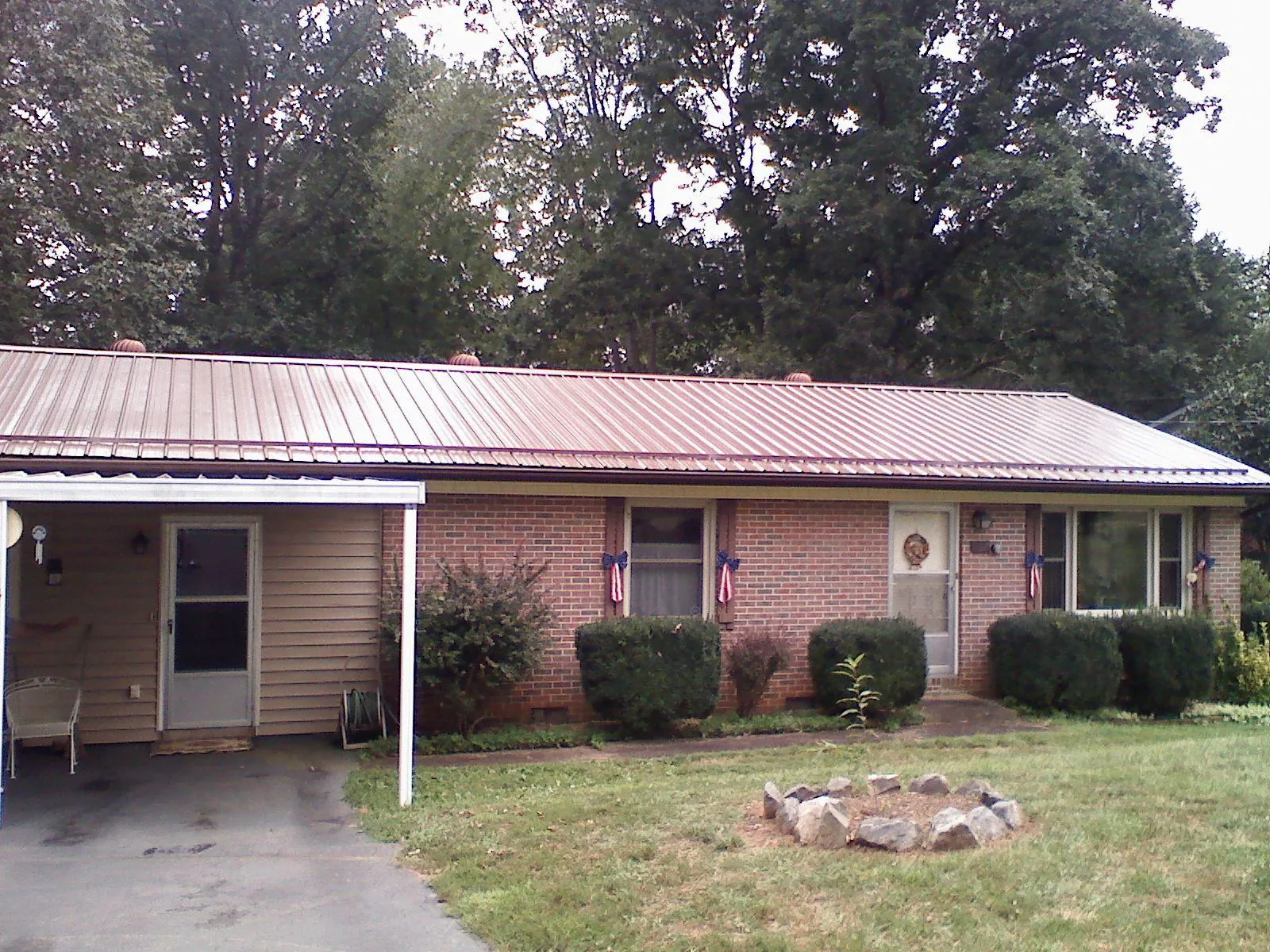 Bronze metal roof and carport on a brick ranch home — Roof Repair work by our crew in Amissville